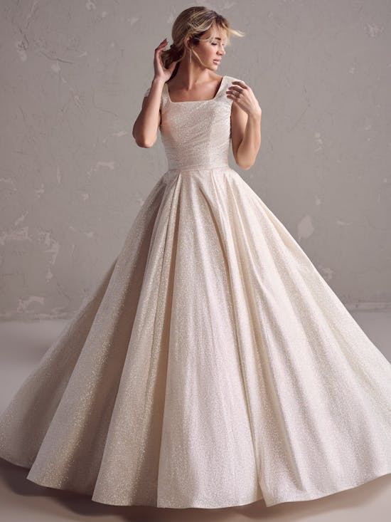 Woman wearing a white wedding dress against a plain background
