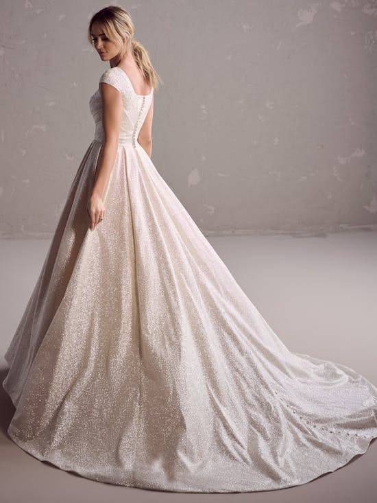 White wedding dress with a long train on a plain background