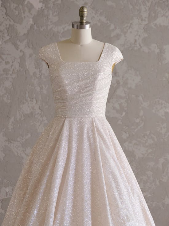White lace dress on a mannequin against a textured gray background