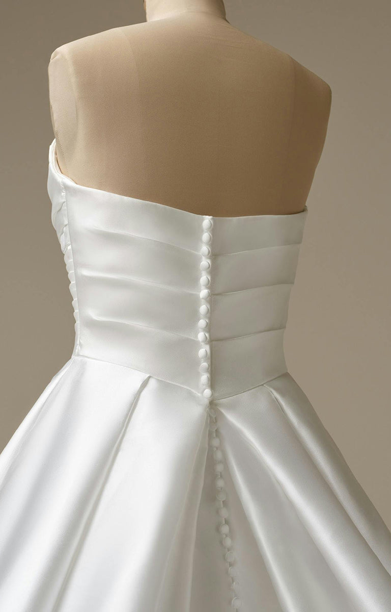 Woman wearing Aubrielle Marie by Maggie Sottero - Reena Mikado Asymmetrical Pleated Ball Gown