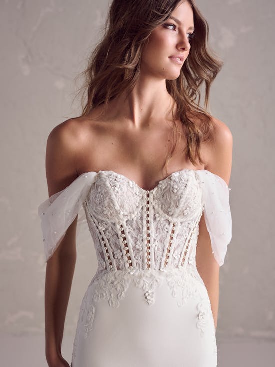 White lace wedding dress with sheer sleeves on a neutral background