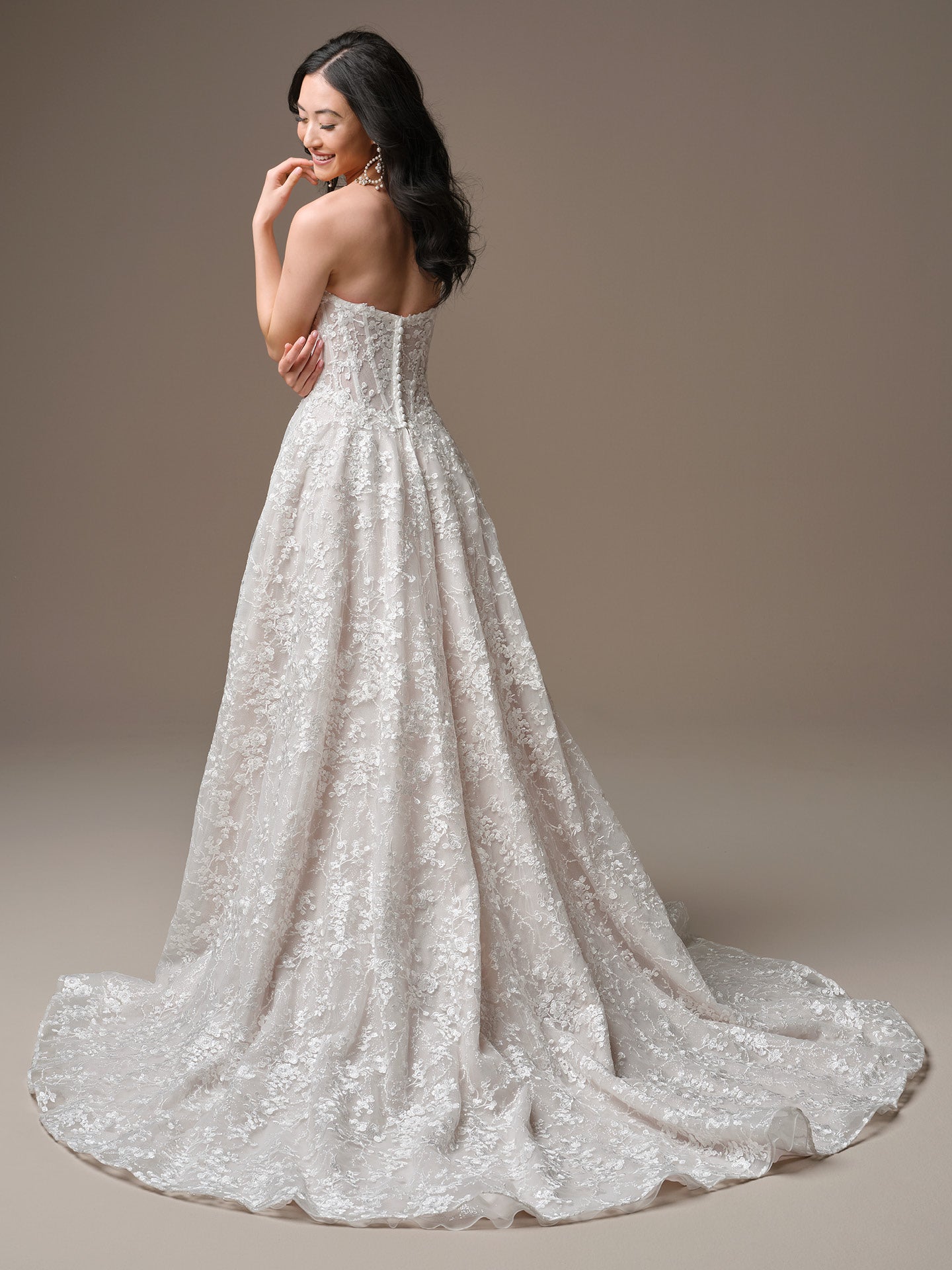 Woman wearing Memphis by Maggie Sottero - Plunging Neckline A-Line Wedding Dress in Ivory over Blush on a plain background
