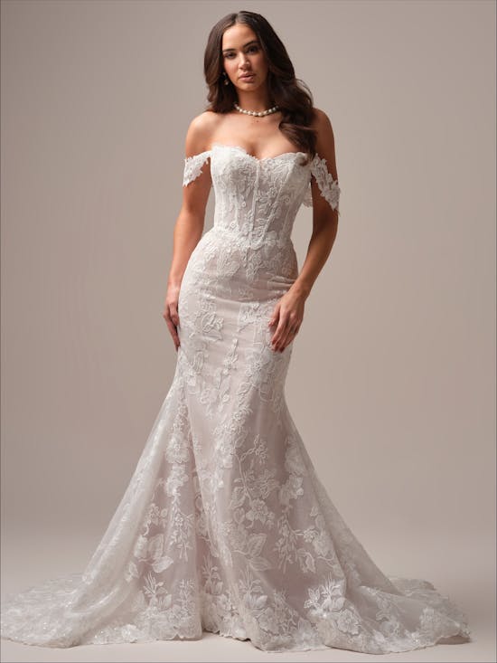 Woman wearing Meredith by Maggie Sottero - a white lace wedding dress against a neutral background