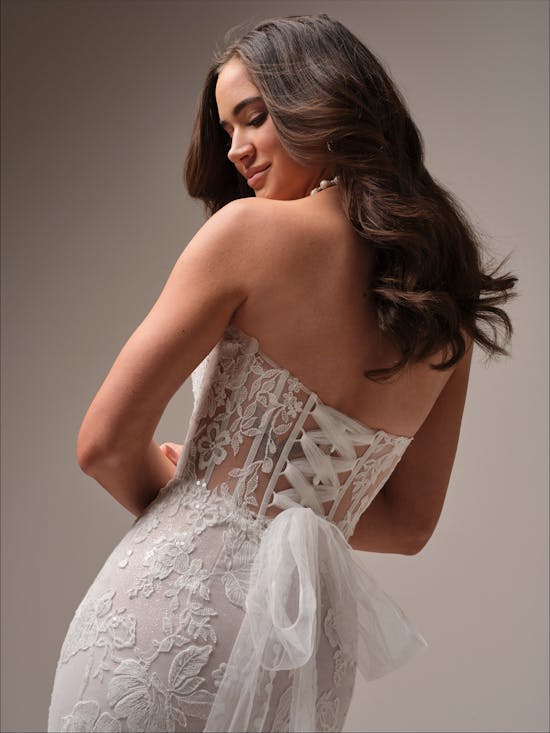 Woman wearing Meredith by Maggie Sottero - a white lace wedding dress against a neutral background