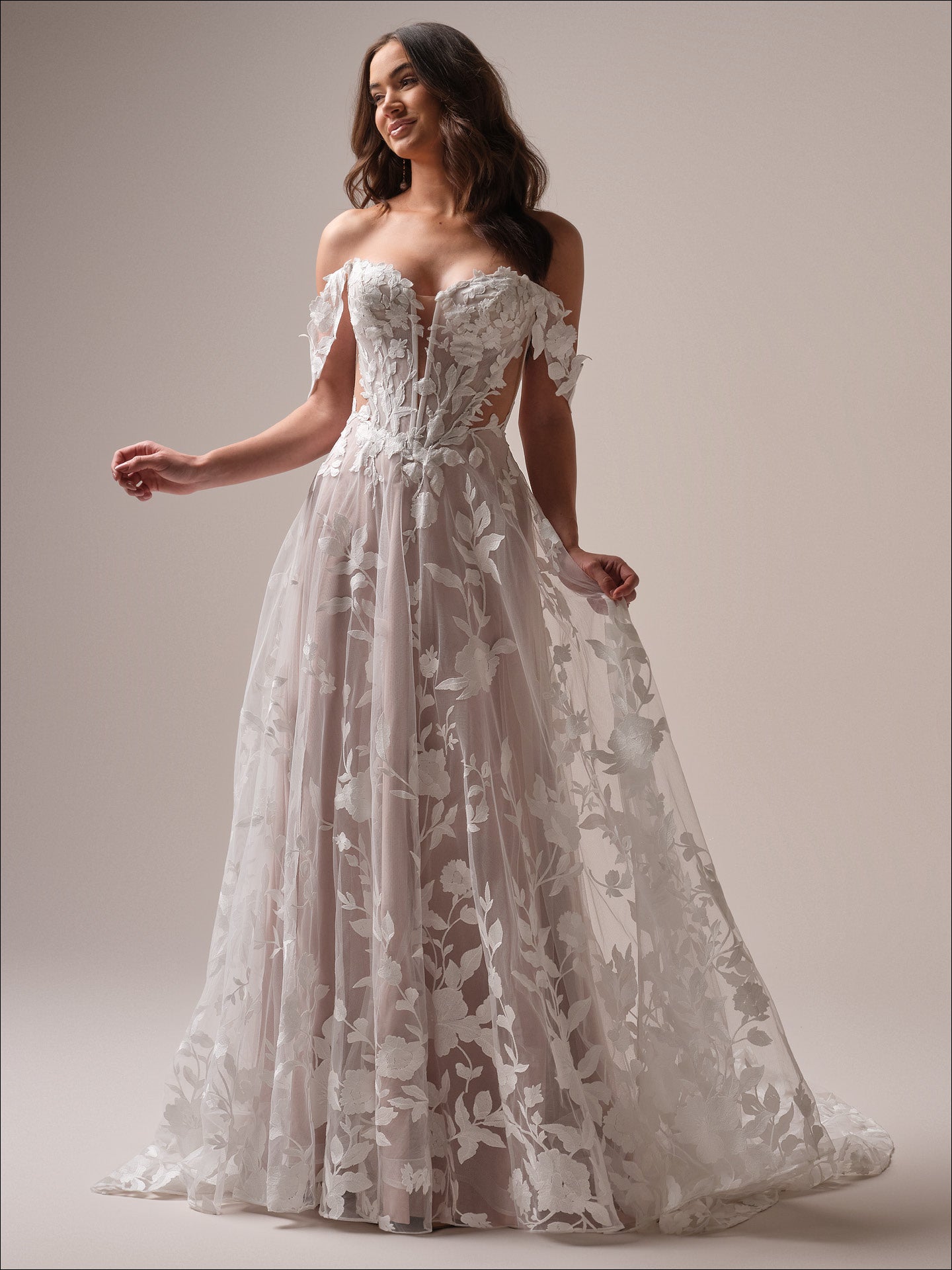 Woman wearing Natalie by Maggie Sottero - Floral A-Line Wedding Dress with Sweetheart Neckline against a plain background