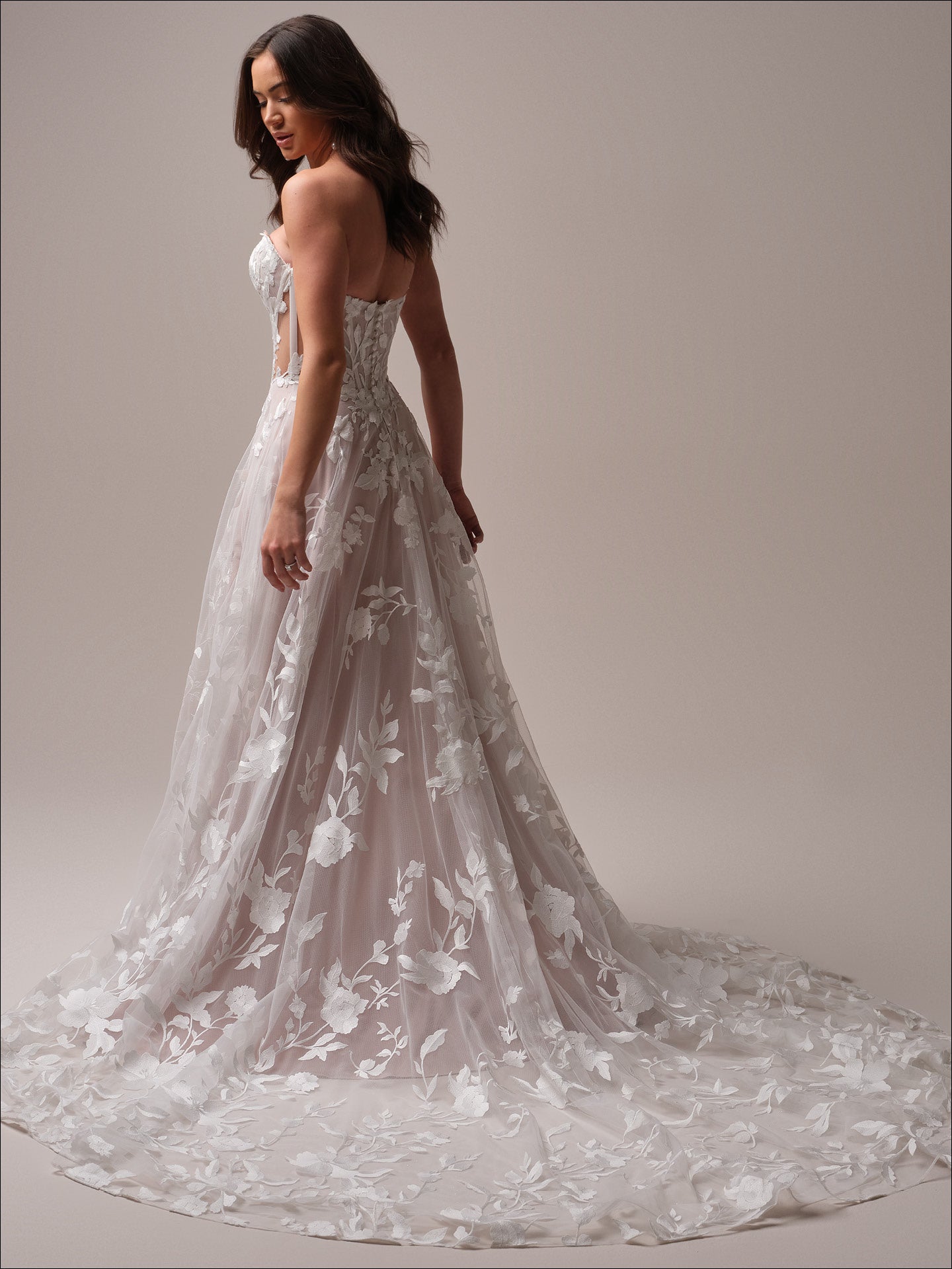 Woman wearing Natalie by Maggie Sottero - Floral A-Line Wedding Dress with Sweetheart Neckline against a neutral background