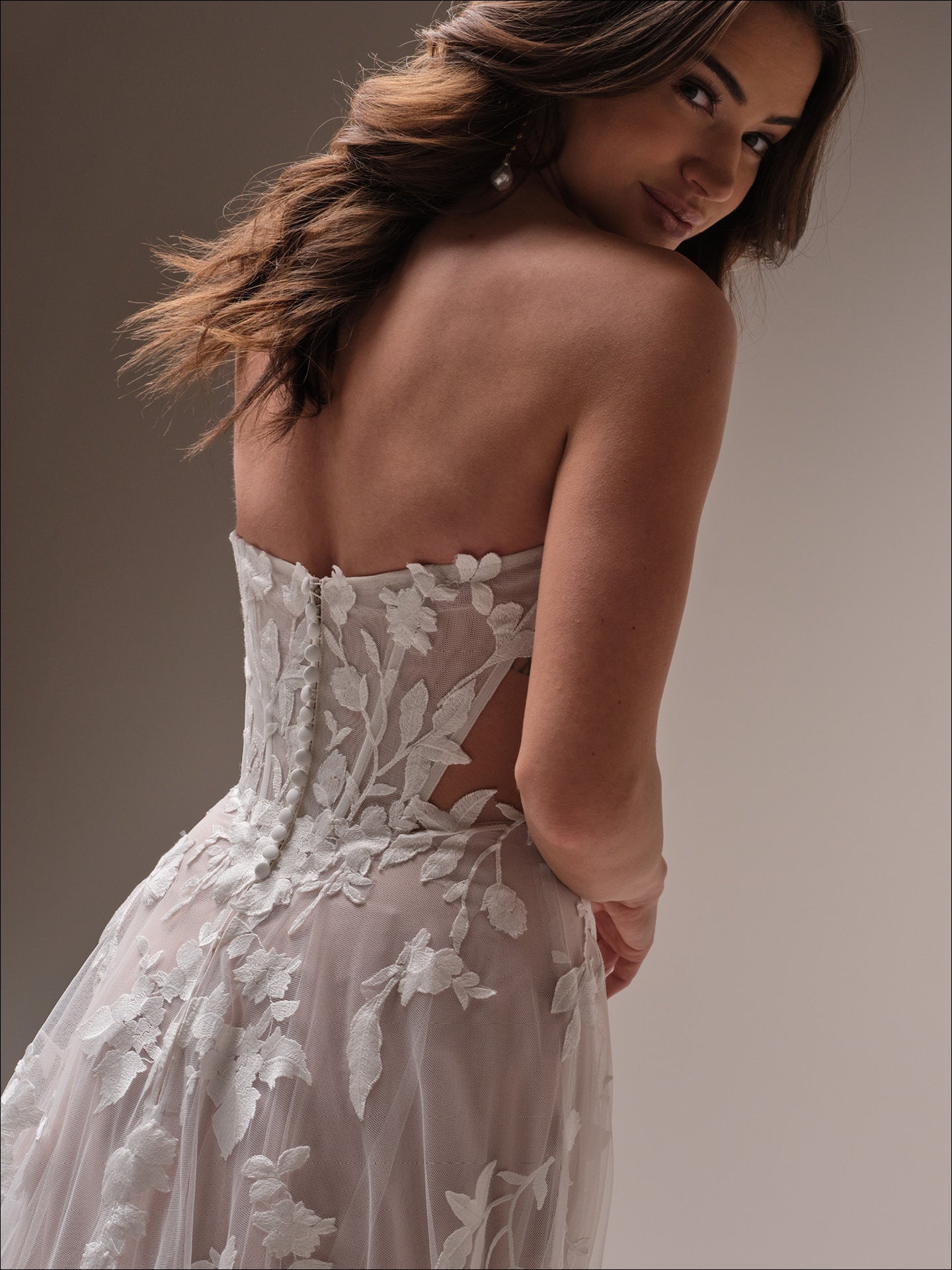 Woman wearing Natalie by Maggie Sottero - Floral A-Line Wedding Dress with Sweetheart Neckline against a neutral background