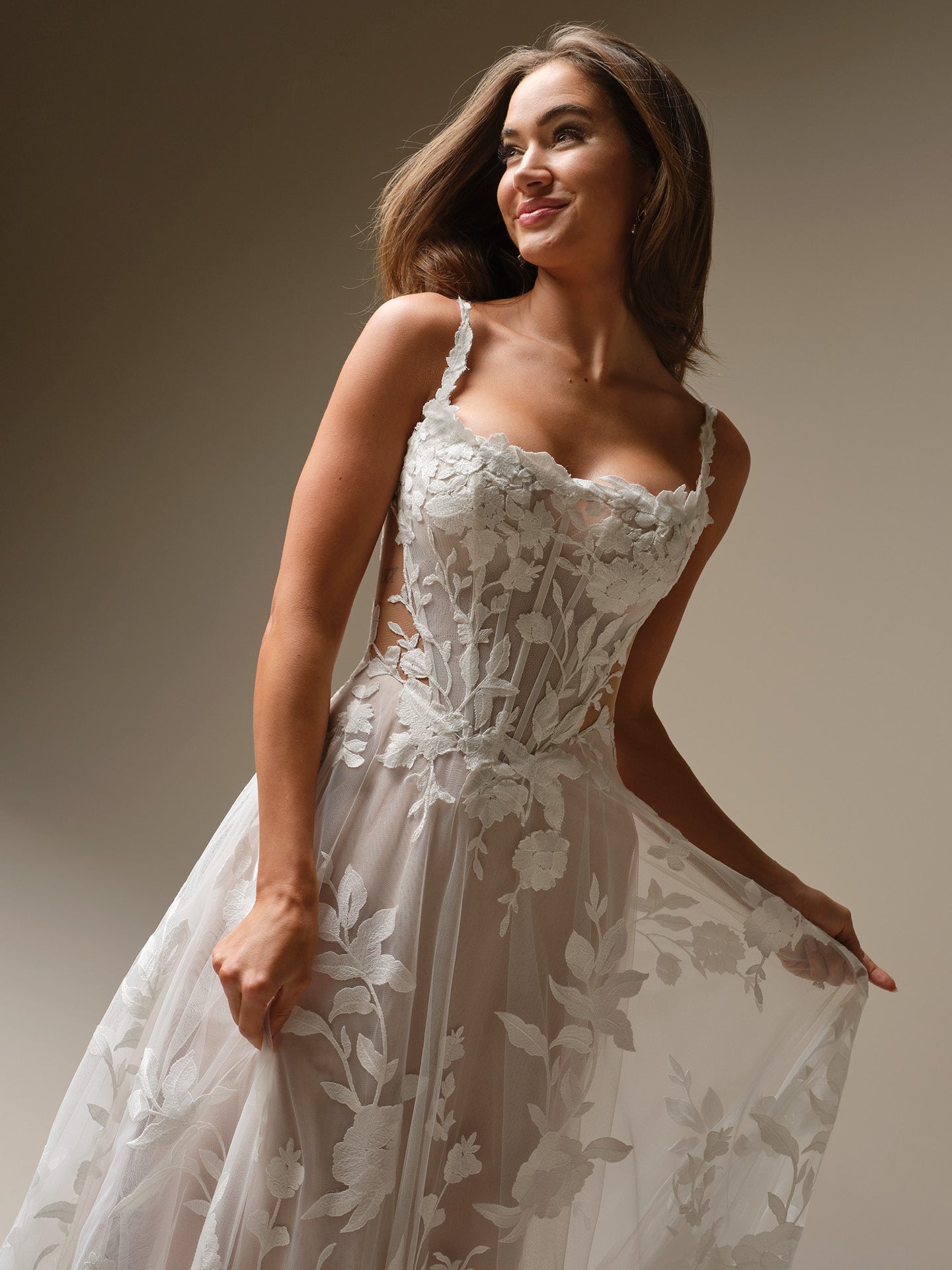Woman wearing Natalie Marie by Maggie Sottero - A-Line Wedding Dress with Plunging Neckline and Floral Lace against a neutral background