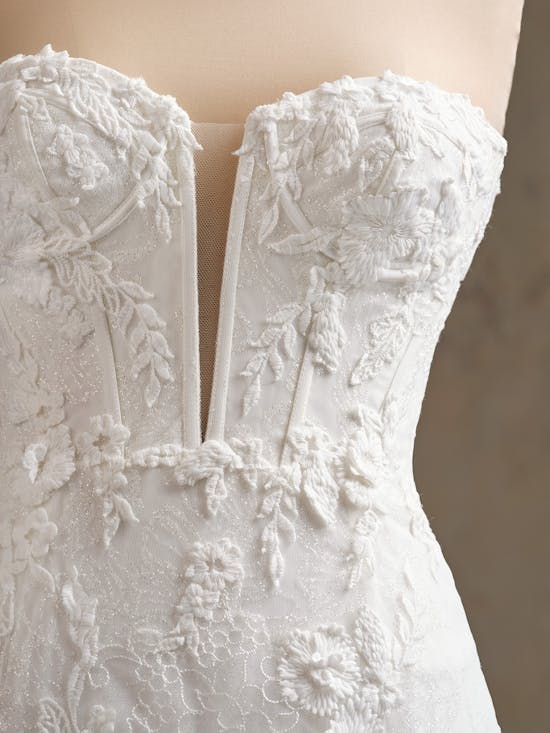 Close-up of Ortensia by Maggie Sottero - a white lace wedding dress with intricate detailing.