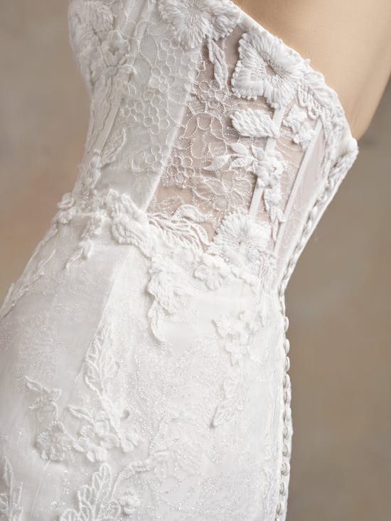 Close-up of Ortensia by Maggie Sottero - a white lace wedding dress on a beige background