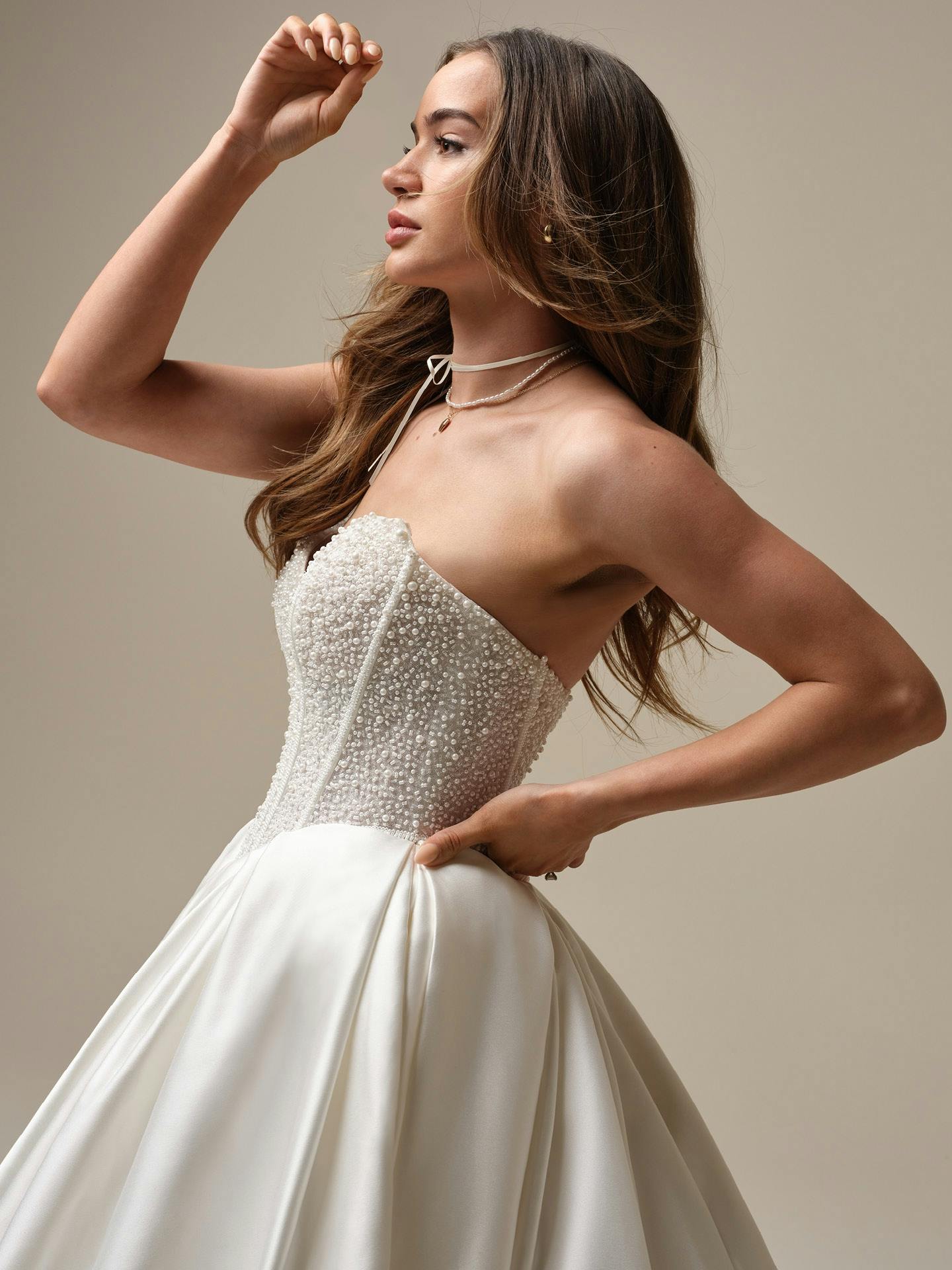Woman wearing a strapless wedding dress with a plain background