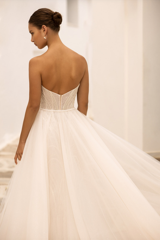 Woman wearing a strapless wedding dress with a plain background