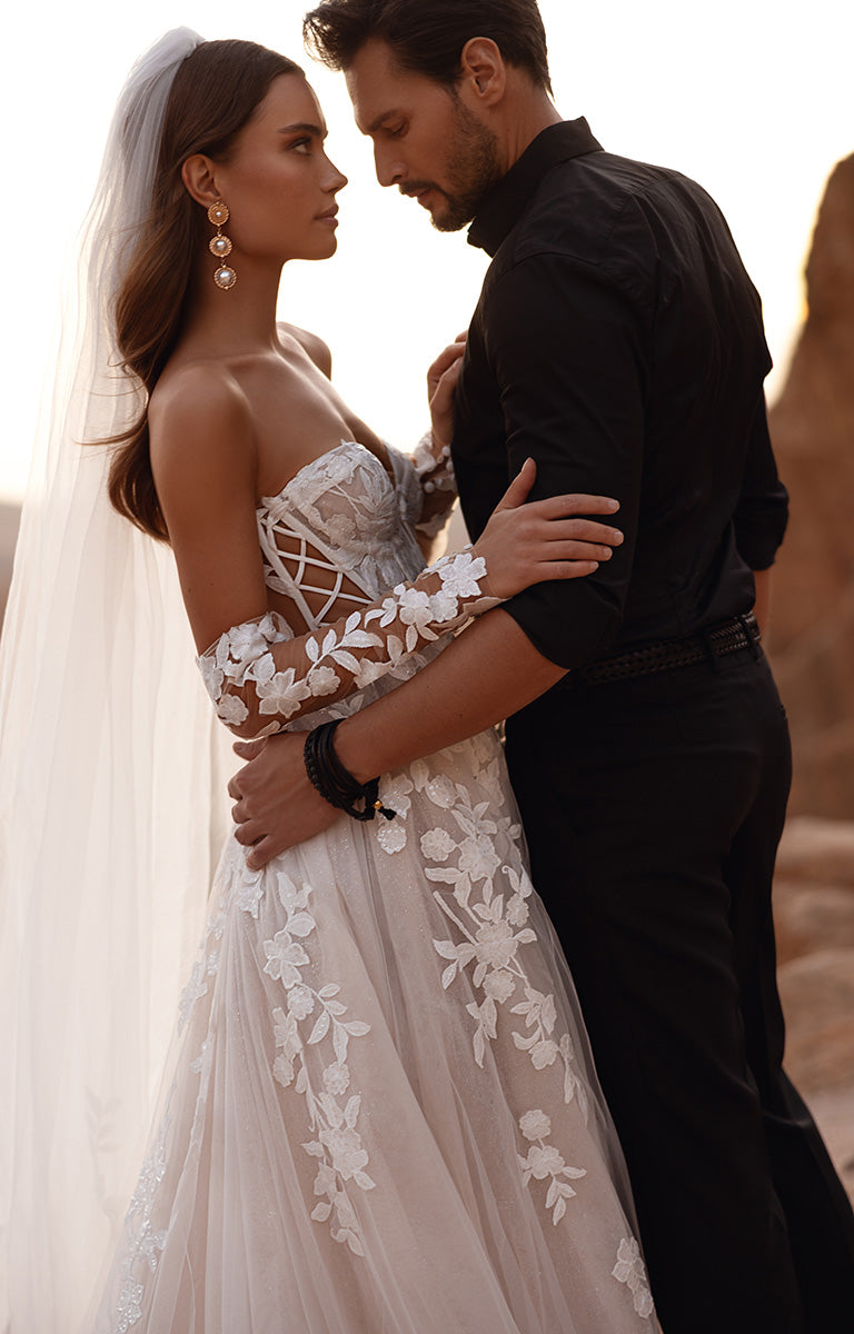 Couple in wedding attire embracing in a desert setting