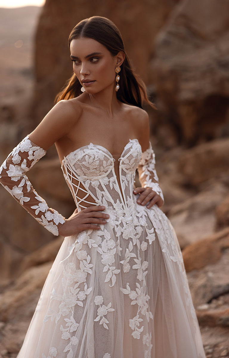 Woman wearing a white lace wedding dress in a desert setting