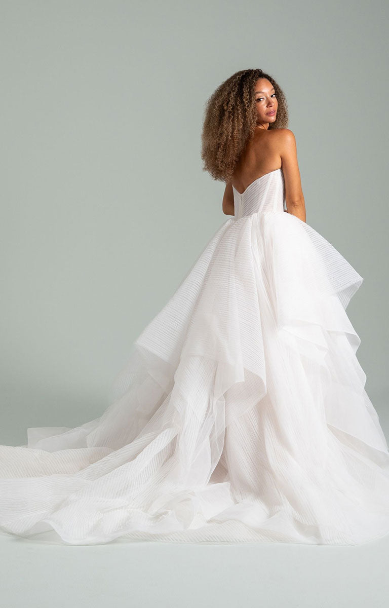 Woman wearing Once I Was a Swan by Hayley Paige - Layered Tulle Ballgown Wedding Dress with Corset Bodice against a gray background