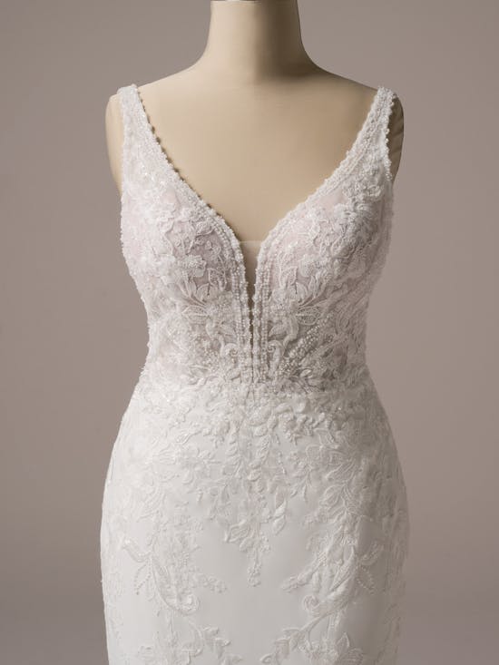 White lace wedding dress on a mannequin against a neutral background