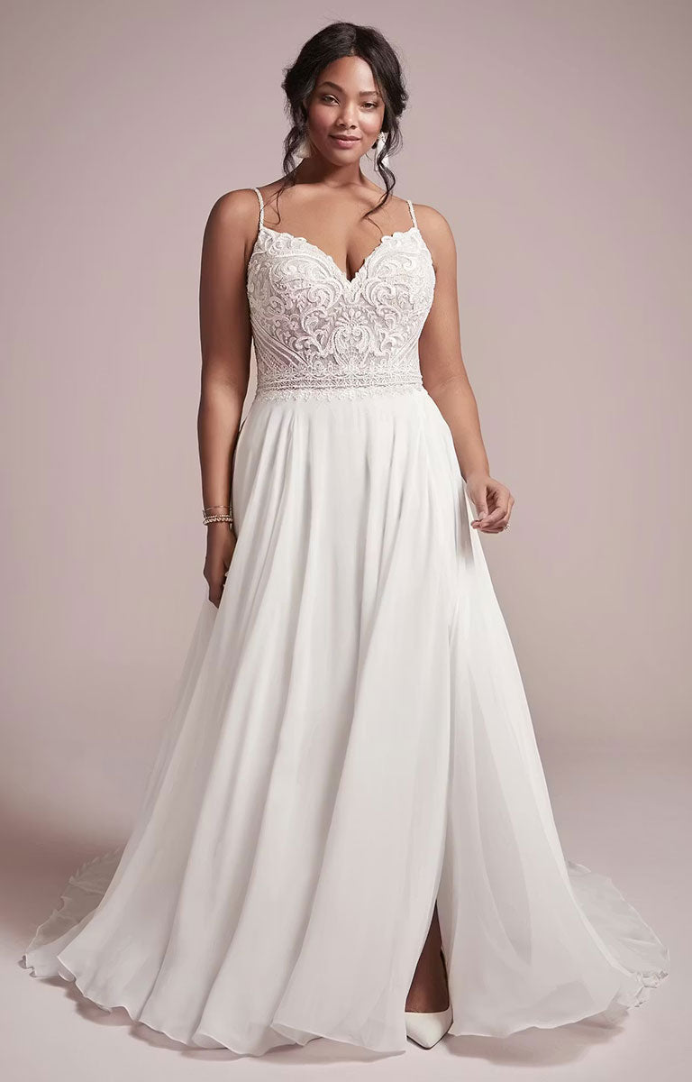 Woman wearing Lorraine by Rebecca Ingram - Beaded Chiffon Sheath Wedding Dress with V-Neckline and Split with lace top and flowing skirt on a light pink background