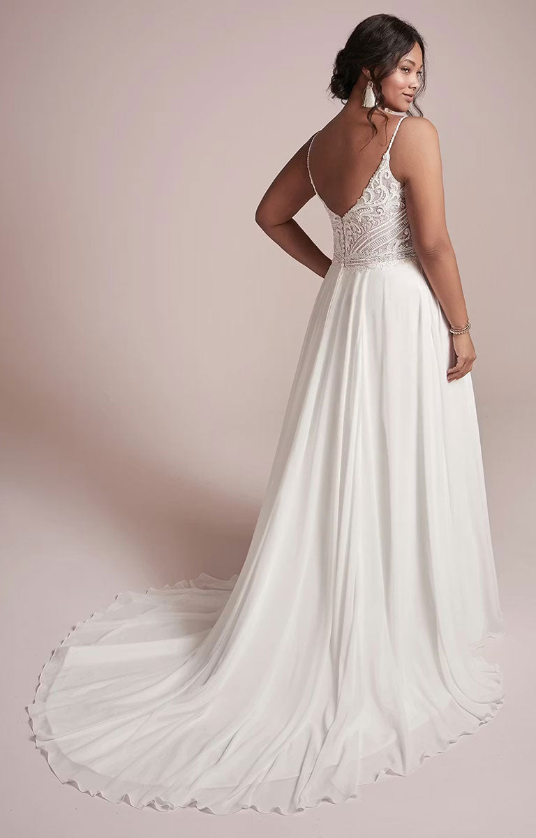 Lorraine by Rebecca Ingram - Beaded Chiffon Sheath Wedding Dress with V-Neckline and Split and flowing skirt on a model against a pink background