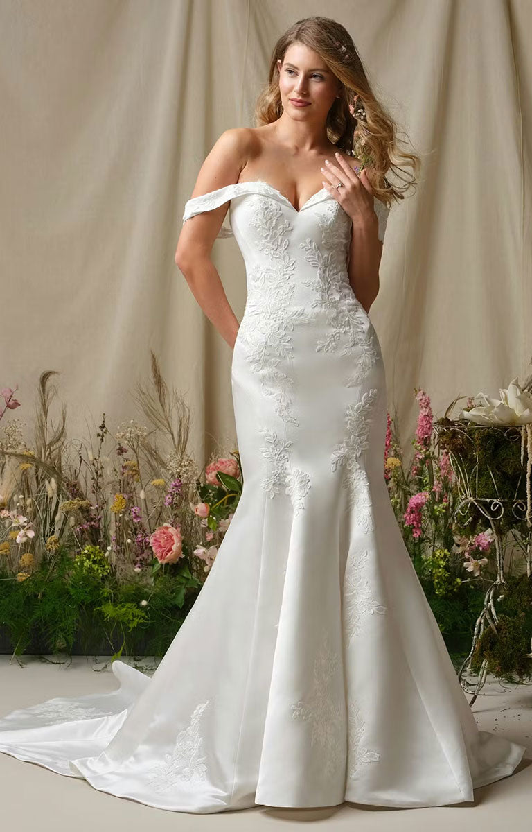Woman wearing Miley by Rebecca Ingram - Off-the-Shoulder Fit-and-Flare Wedding Dress with Sequined Lace Accents in a garden setting