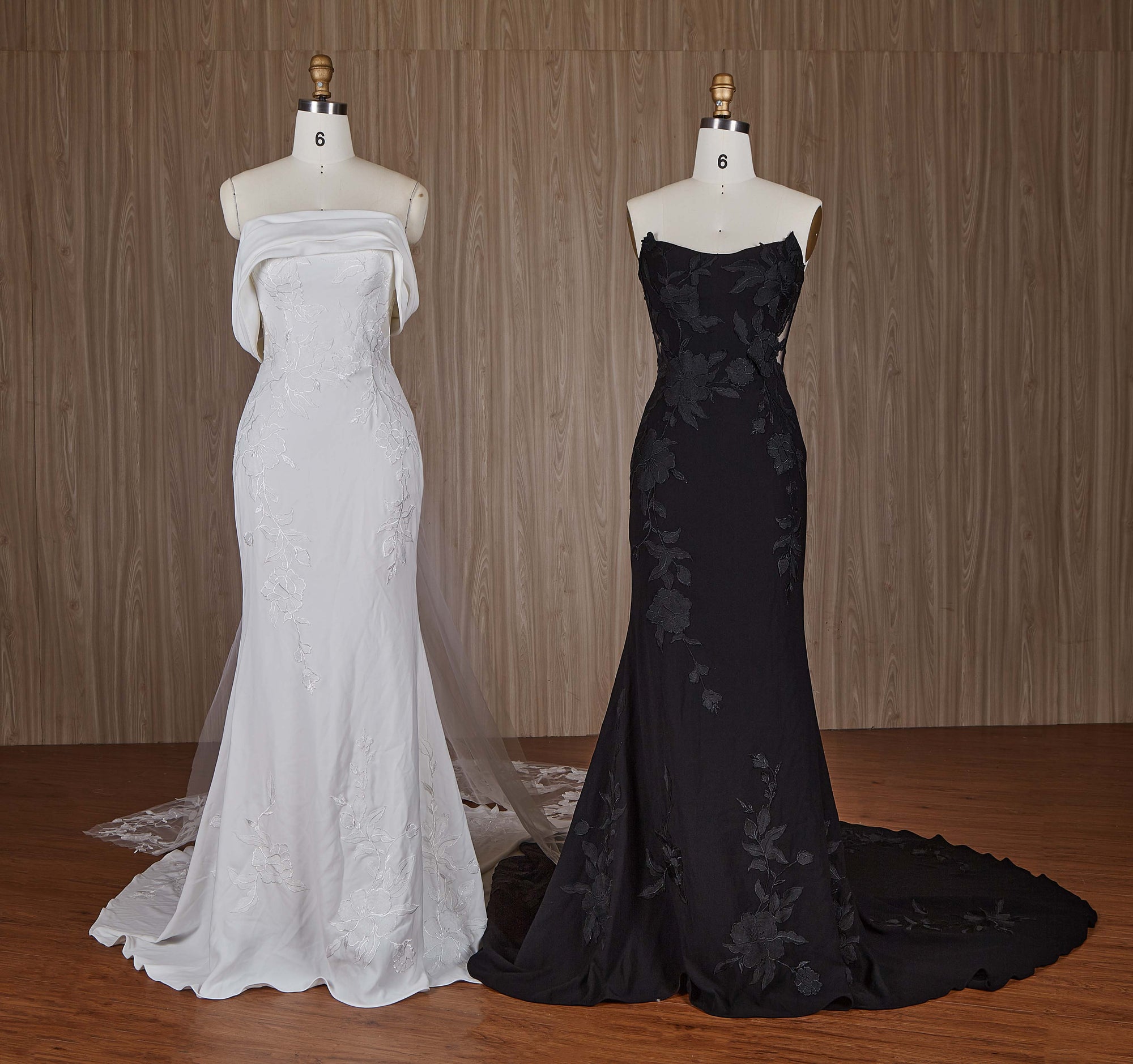 White and black evening gowns on mannequins against a wooden background