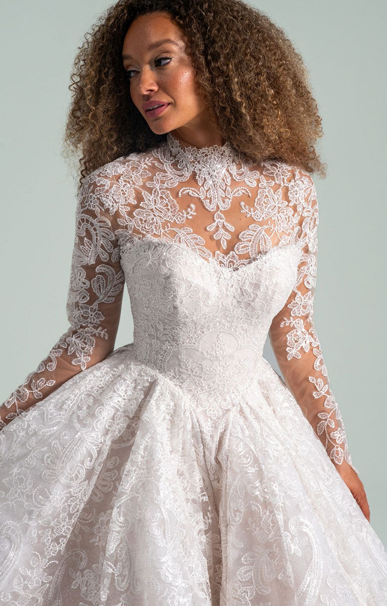 Woman wearing She Who Hung the Moon by Hayley Paige - Lace Ballgown Wedding Dress with Detachable Bolero against a light gray background