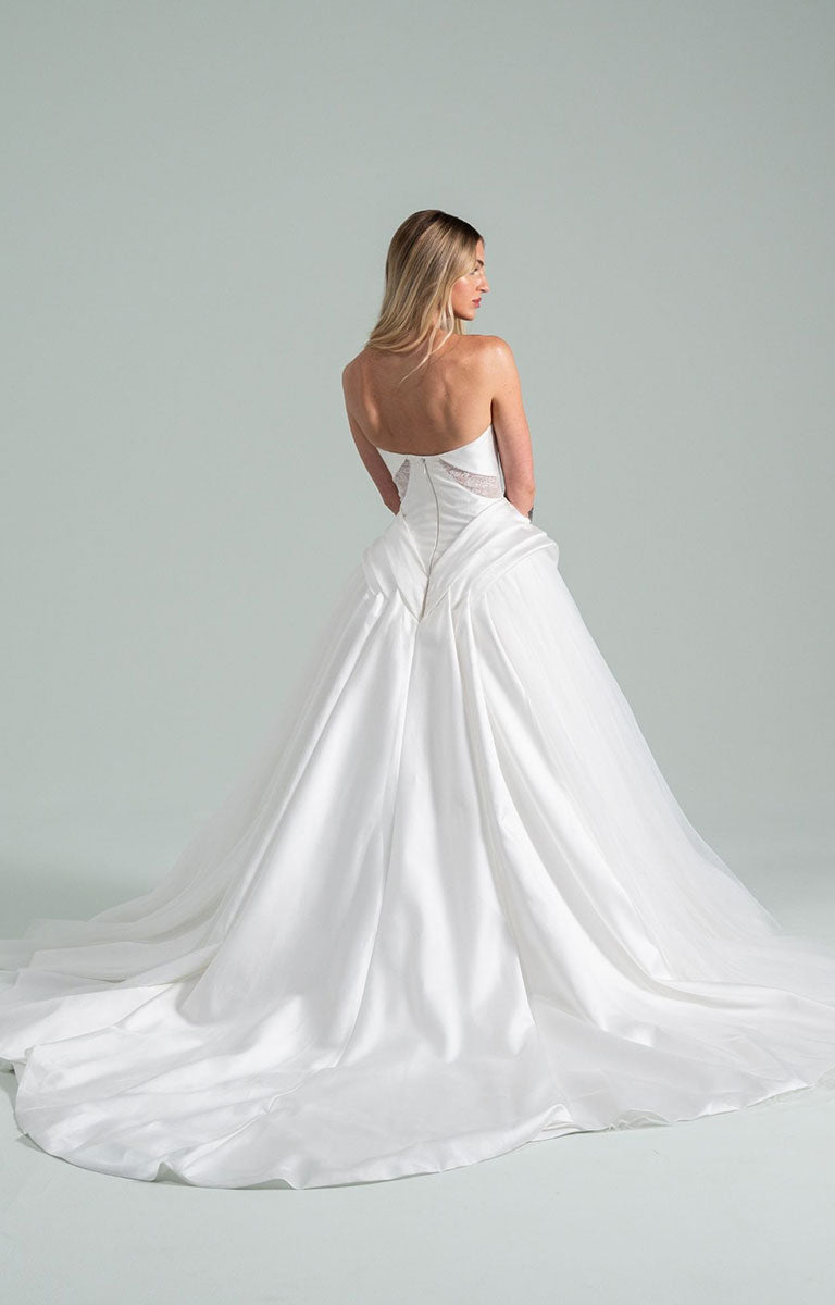 Woman wearing Sonnet 104 by Hayley Paige - Satin and Tulle Ballgown Wedding Dress with Draped Corset Bodice on a plain background