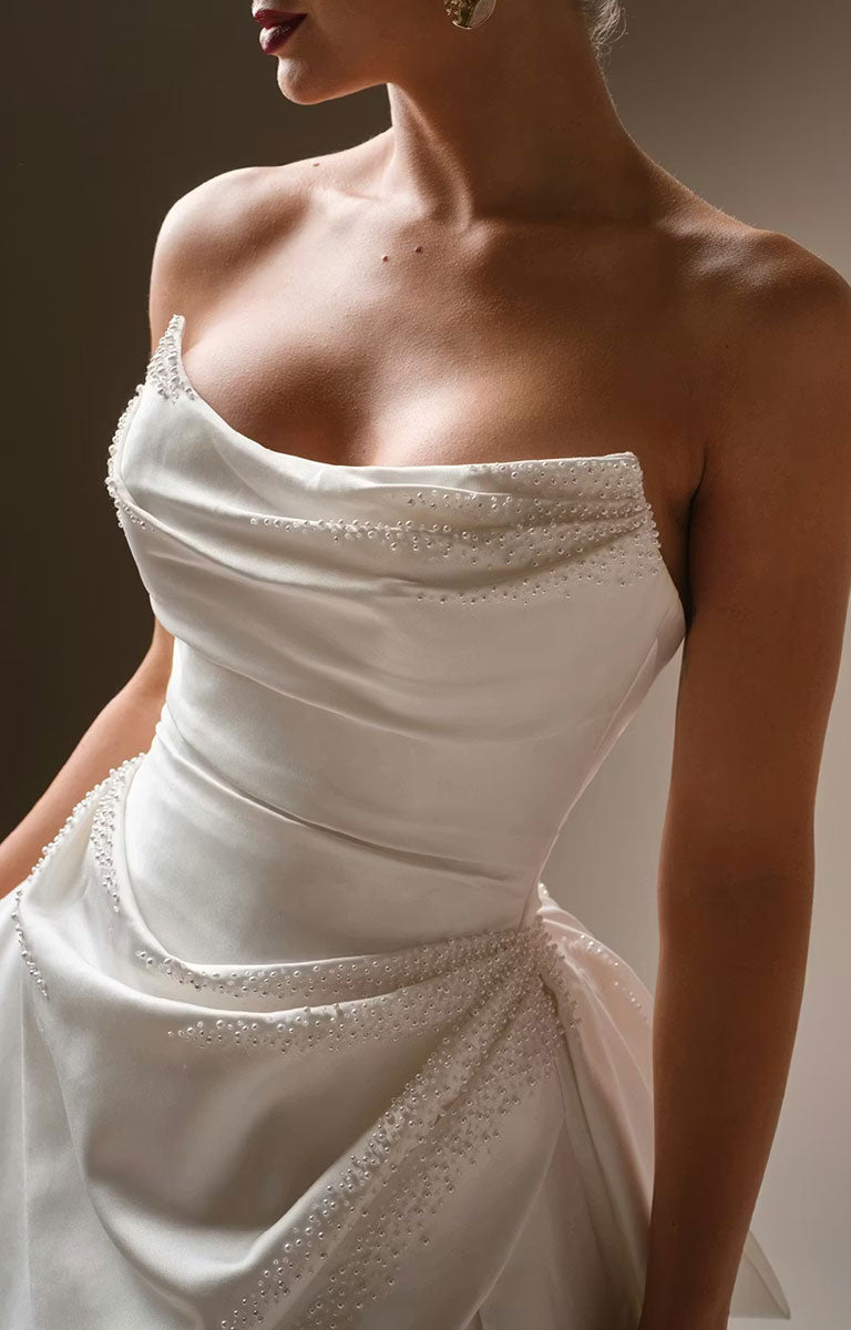 Kincaid by Sottero and Midgley - Ruched Satin Ballgown Wedding Dress with Pearl Details and Cat-Eye Neckline with intricate detailing on a plain background