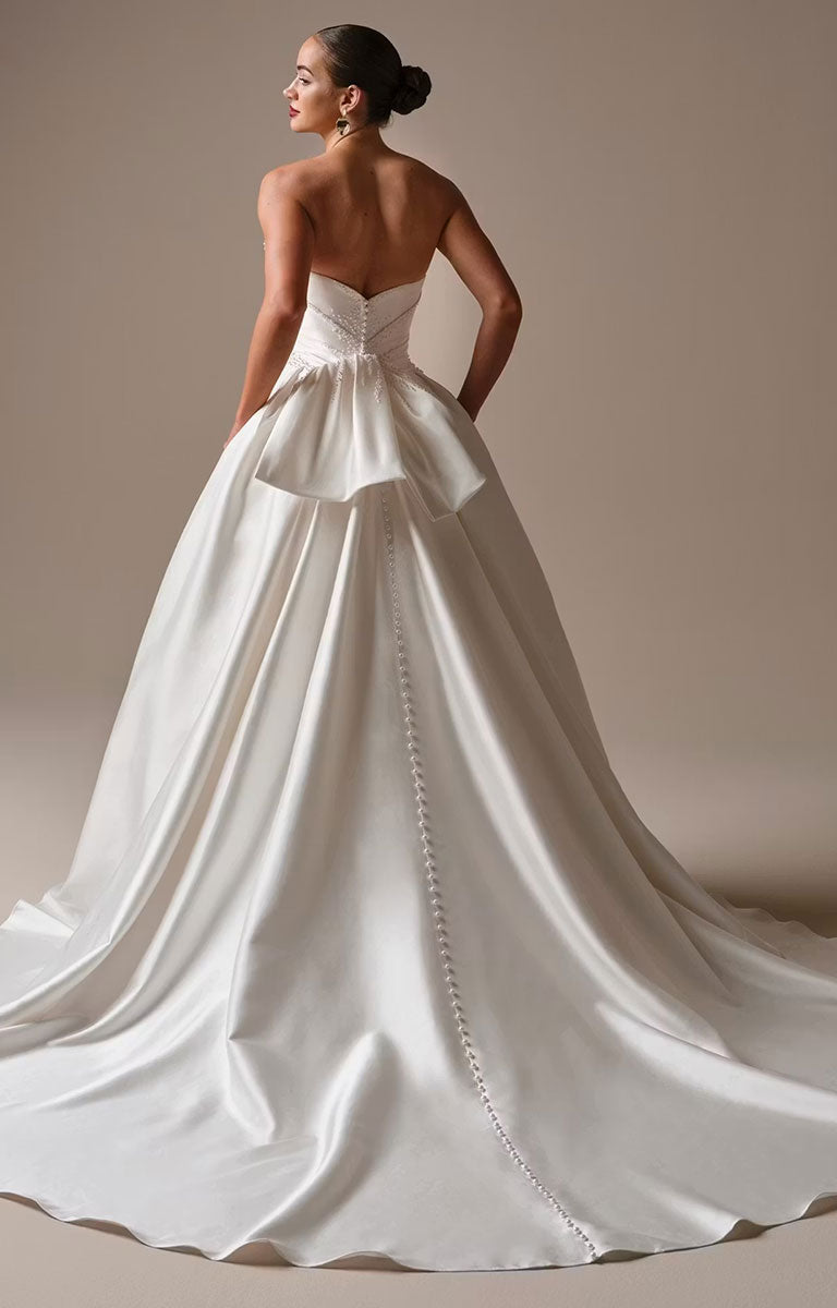 Kincaid by Sottero and Midgley - Ruched Satin Ballgown Wedding Dress with Pearl Details and Cat-Eye Neckline with a long train on a neutral background
