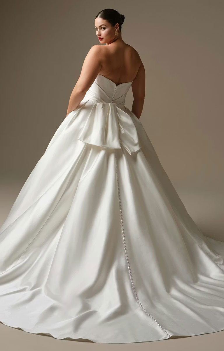 Woman wearing Kincaid by Sottero and Midgley - Ruched Satin Ballgown Wedding Dress with Pearl Details and Cat-Eye Neckline with a plain background