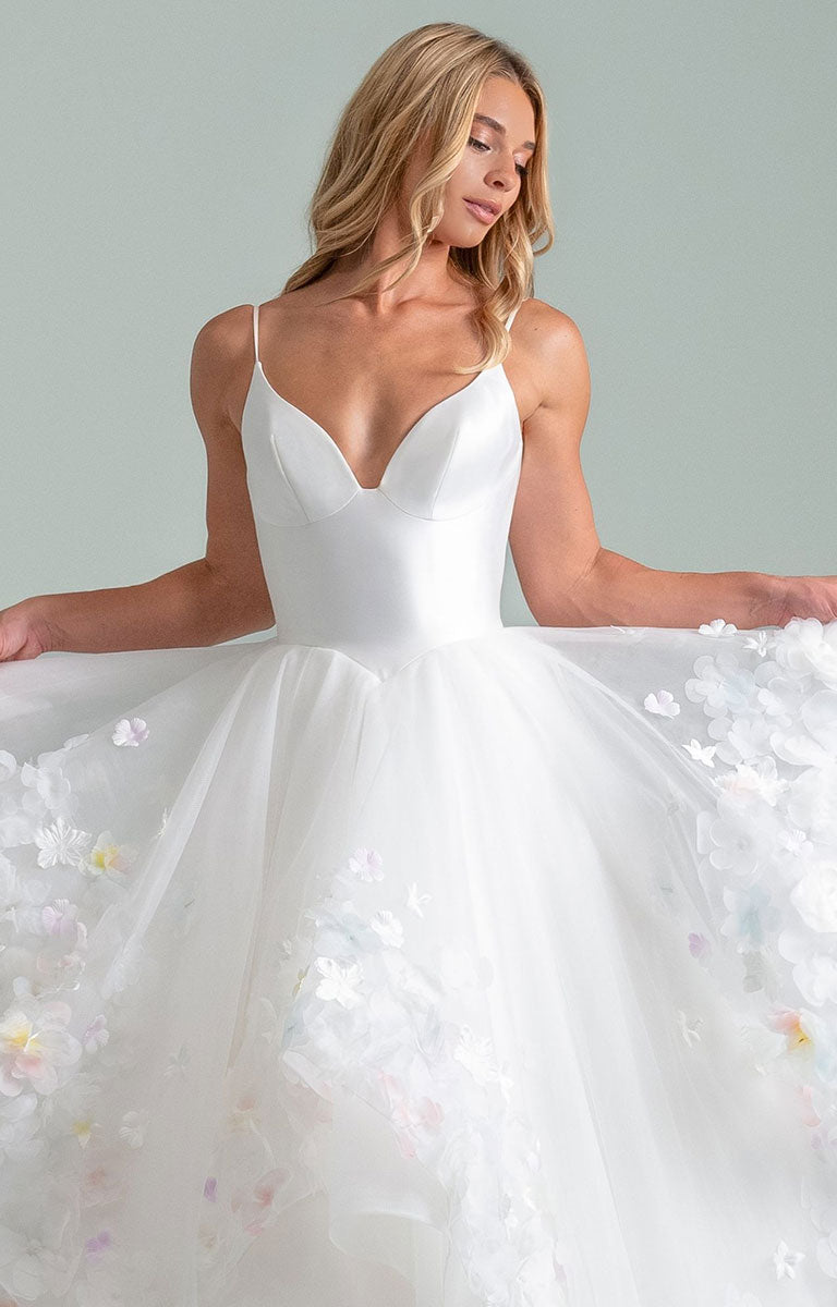 Woman wearing Turning Paiges by Hayley Paige - Layered Organza Ballgown Wedding Dress with Floral Petal Detail with a soft gray background