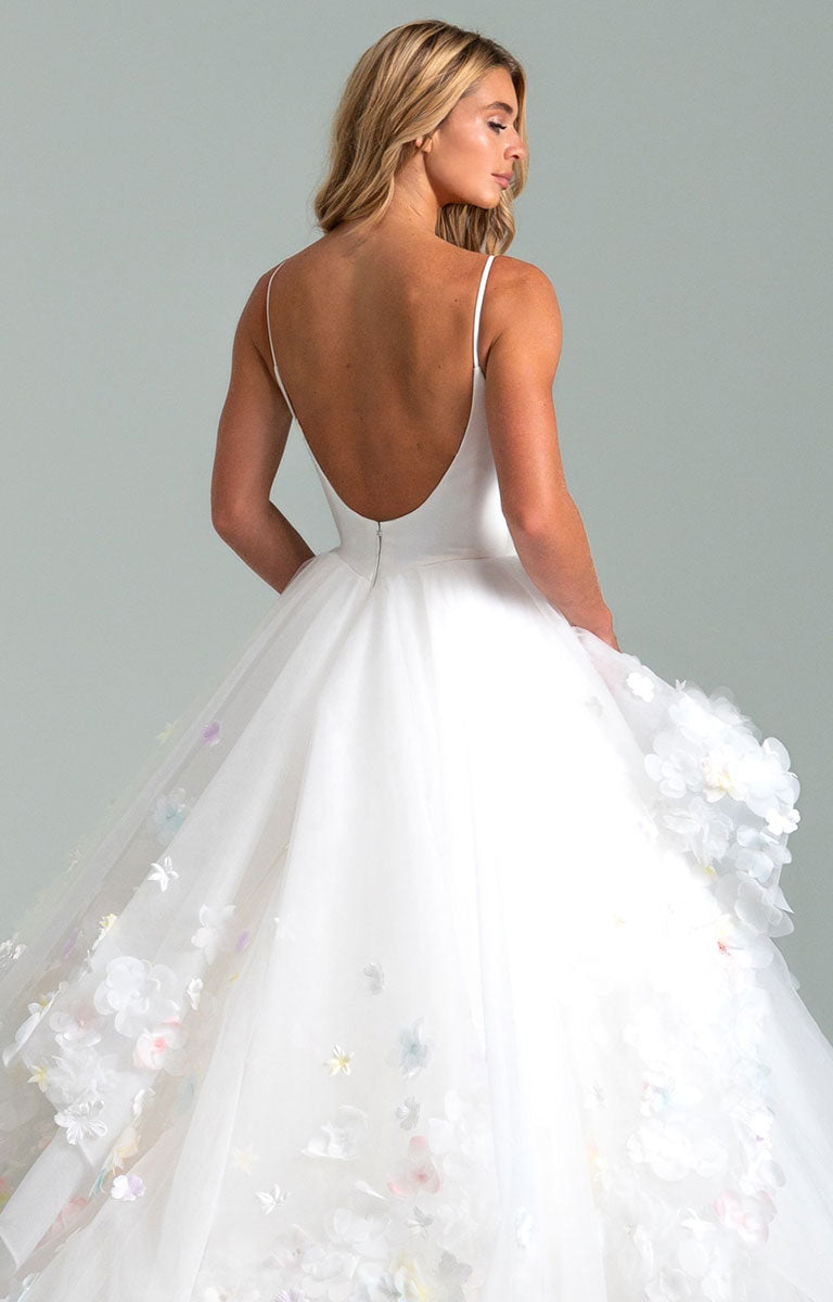 Woman wearing Turning Paiges by Hayley Paige - Layered Organza Ballgown Wedding Dress with a open back and floral details on a gray background