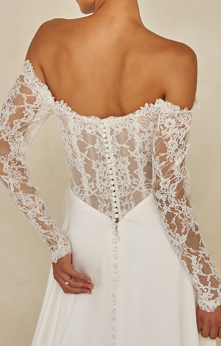 Ward by Madi Lane Bridal - White lace wedding dress with long sleeves on a neutral background