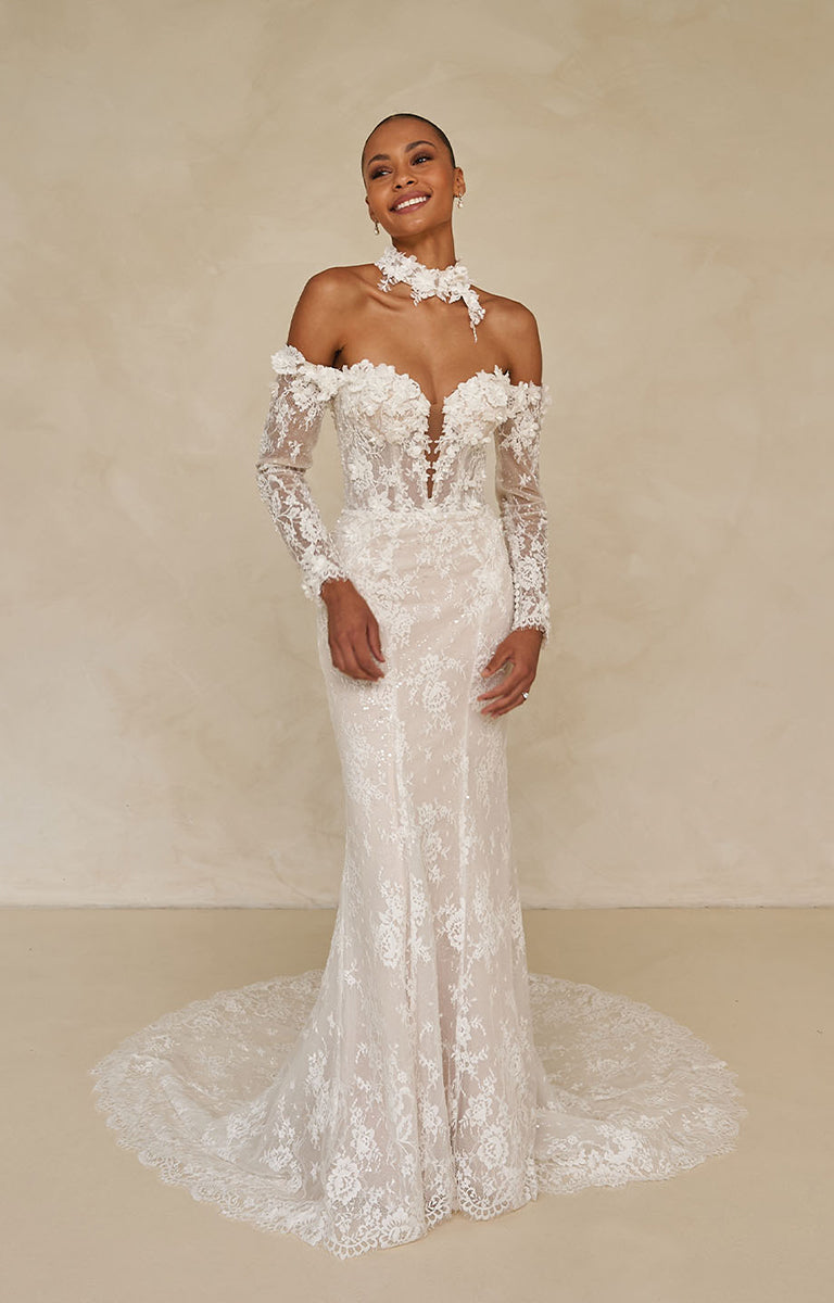 Woman wearing a white lace wedding dress against a beige background