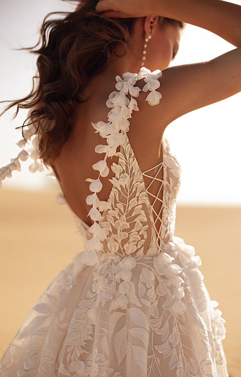 White lace wedding dress with floral details in a desert setting