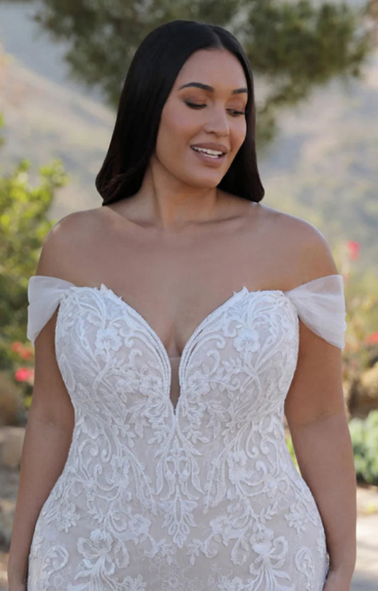 Woman wearing Athénais by ÉLYSÉE Edition - Floral Baroque Lace Wedding Dress with Sculpted Train and Detachable Sleeves with a scenic background