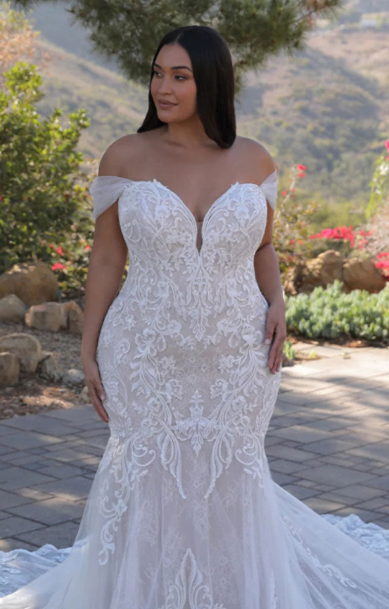 Woman wearing Athénais by ÉLYSÉE Edition - Floral Baroque Lace Wedding Dress with Sculpted Train and Detachable Sleeves with a Mediterranean hillside and floral setting.