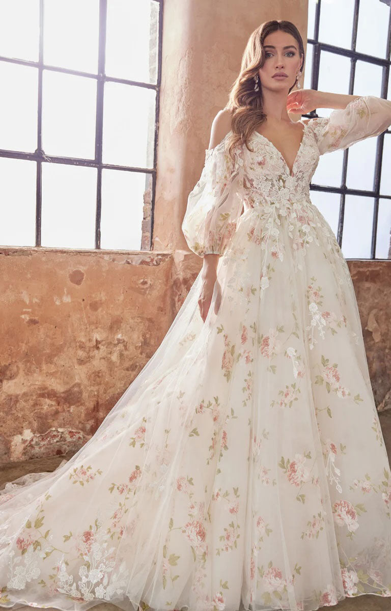 Woman wearing Elora by Josephine Scott - Romantic Rose Print Ballgown Wedding Dress with Lace Appliqué and Voluminous Bell Sleeves in an industrial setting