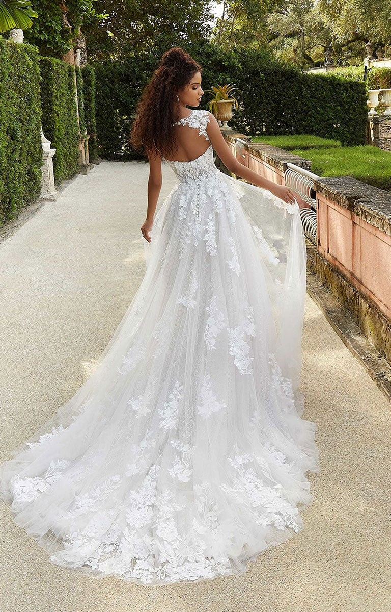 Woman in Fiorenza by Morilee - Romantic Lace and Glitter Tulle Wedding Dress with Sculpted Bodice standing on a path with greenery in the background