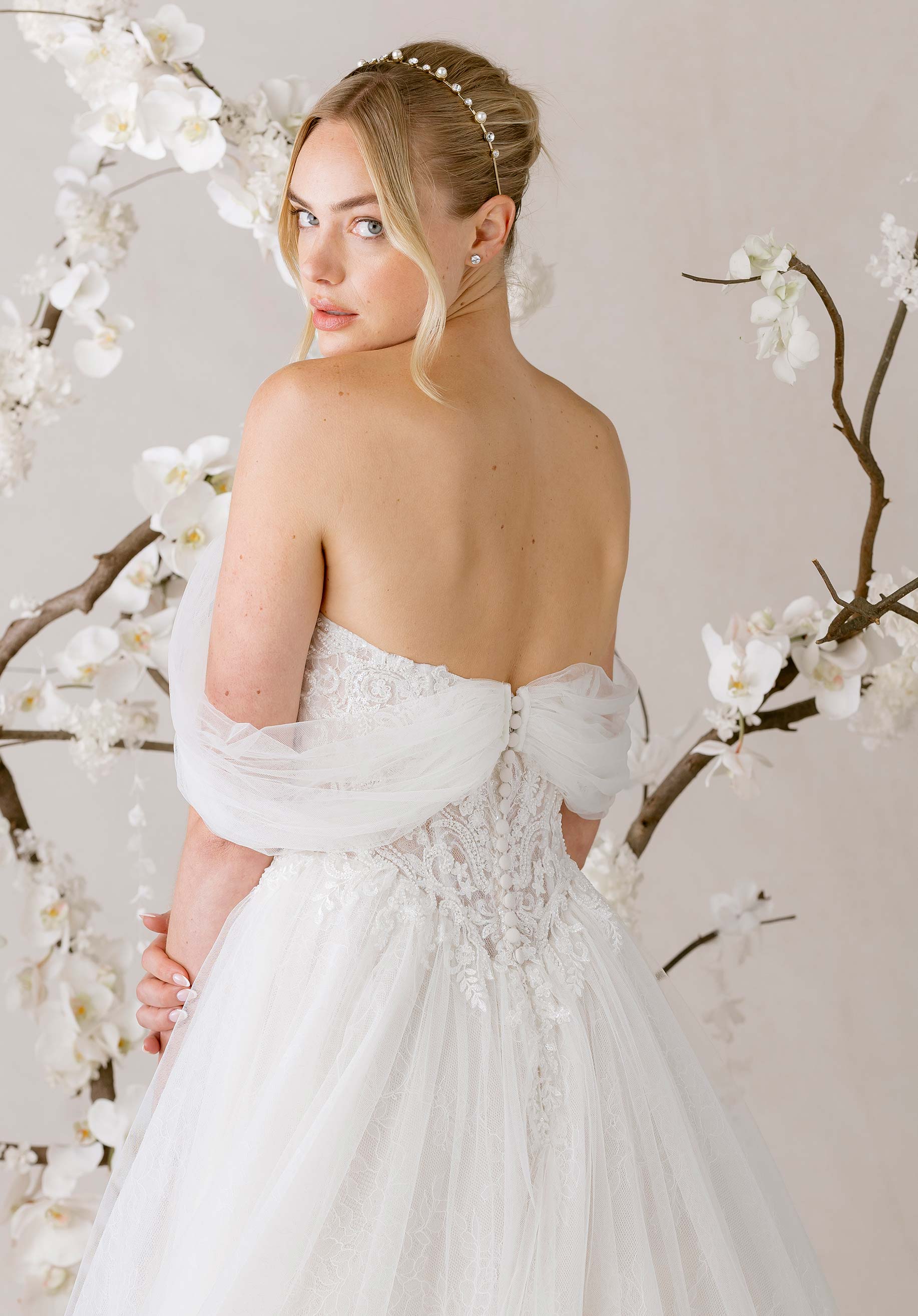 Woman in a white wedding dress standing among white flowers