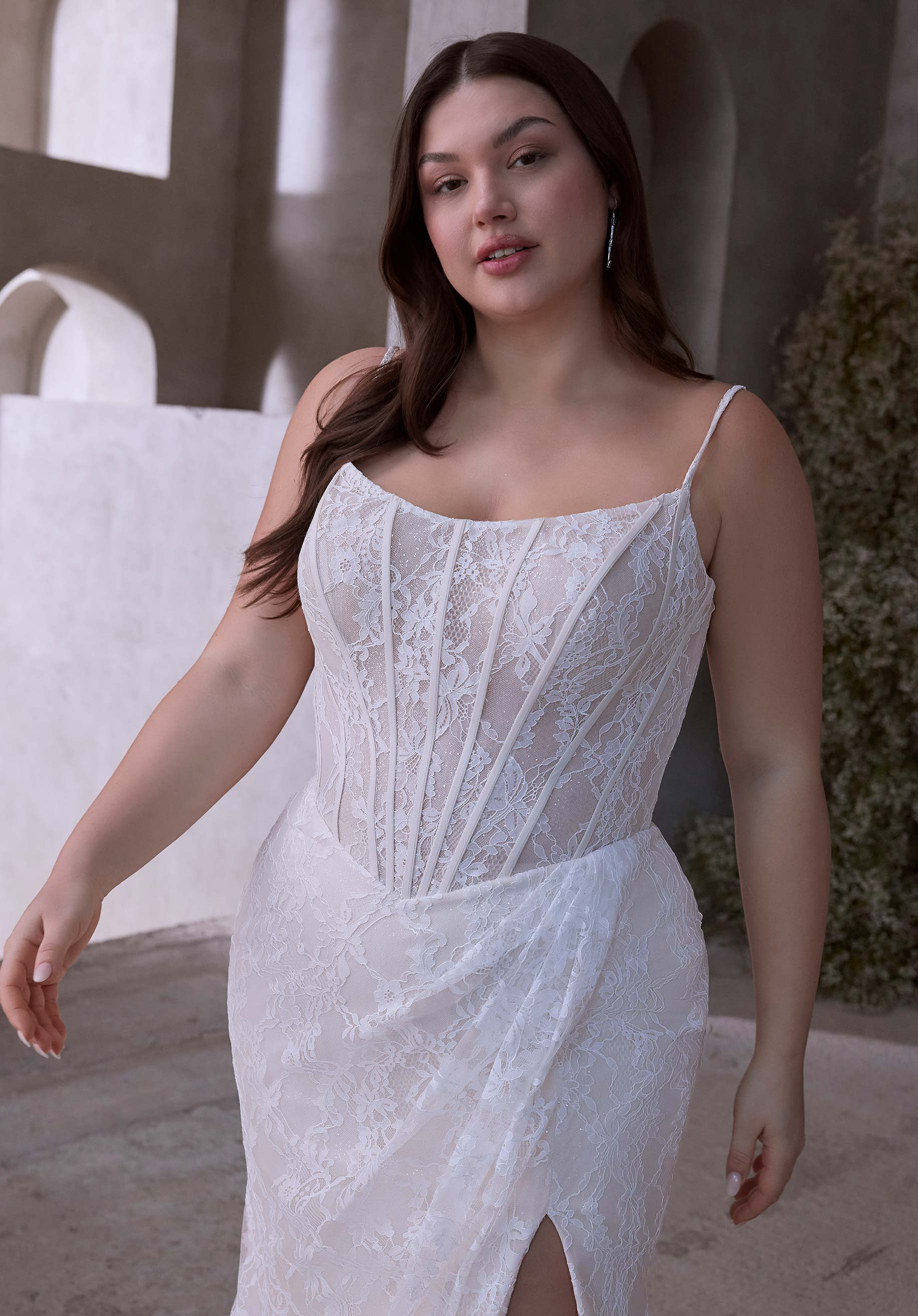 Woman wearing Constantia by Morilee Julietta - a white lace dress standing outdoors.