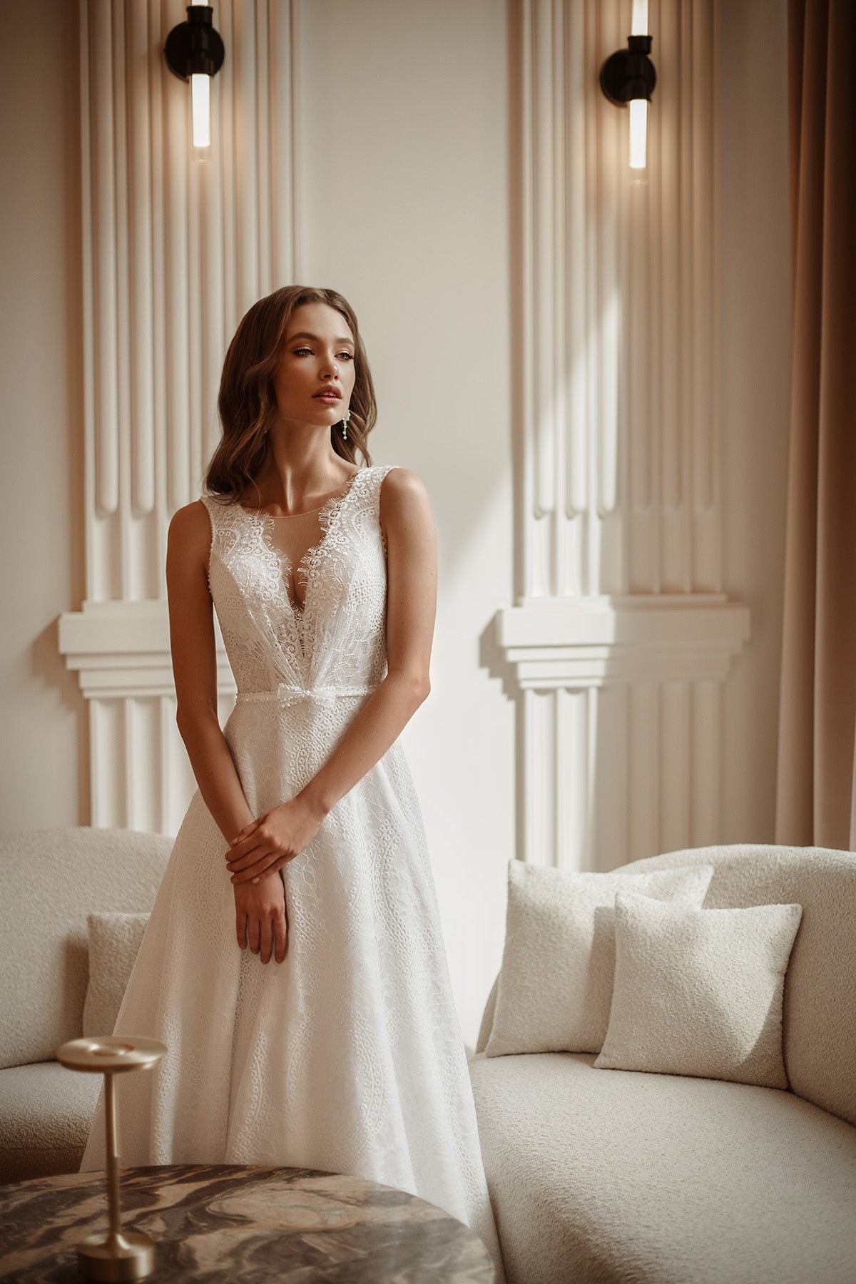 Woman in a white dress standing in a stylish interior setting